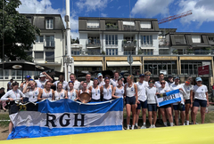 Sportler:innen der RGH mit Vereinsfahne vor dem Gebäude des HRK